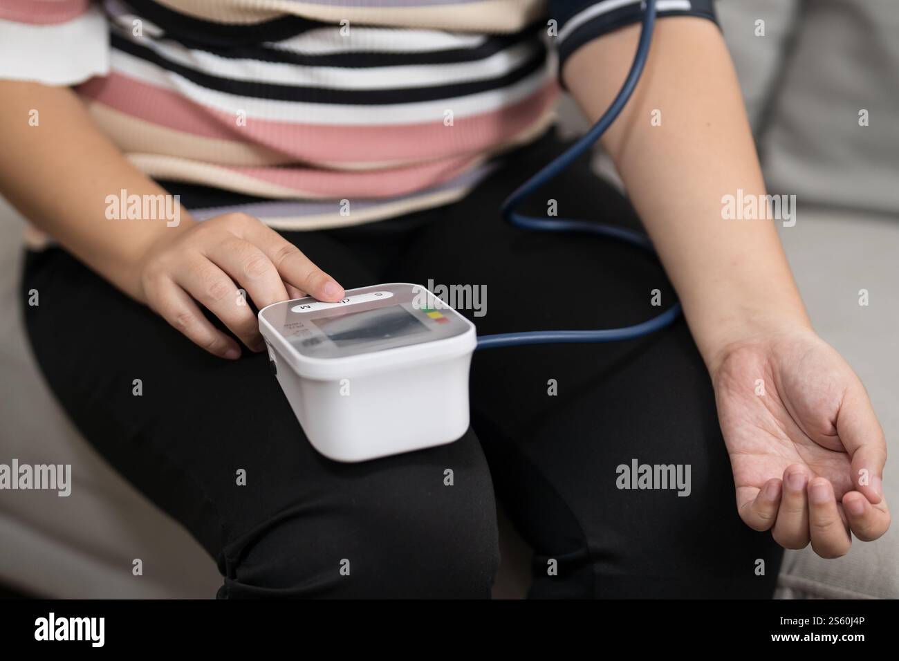 Übergewichtige Frauen plus Größe Selbstkontrollen Blutdruck und Herzfrequenztonometer Selbstkontrolle zu Hause. Stockfoto