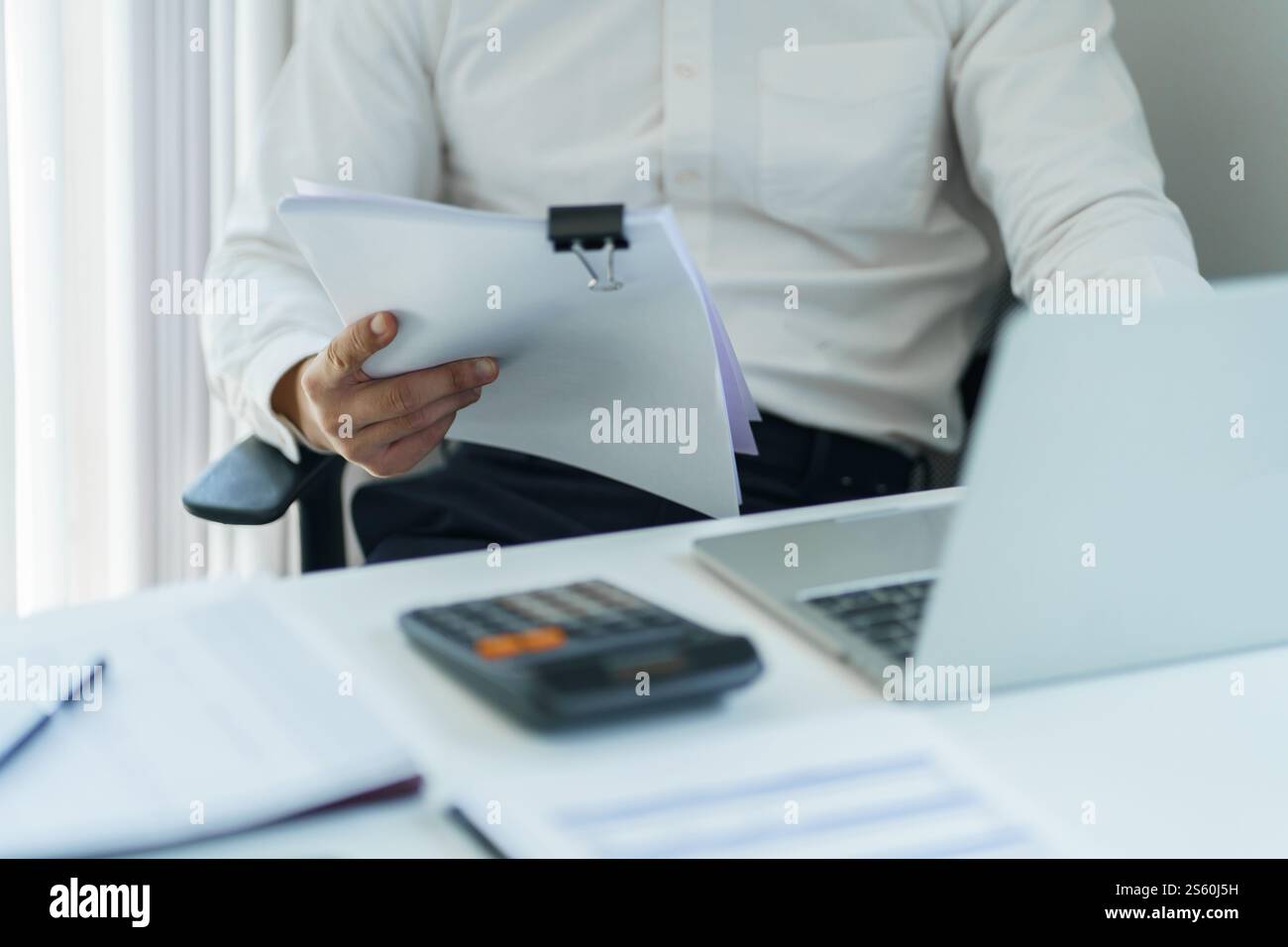 Junger Geschäftsmann, der im Büro arbeitet. Geschäftsmann, der Finanzpapierarbeiten macht, Unternehmensmanagement-Konzept. Stockfoto