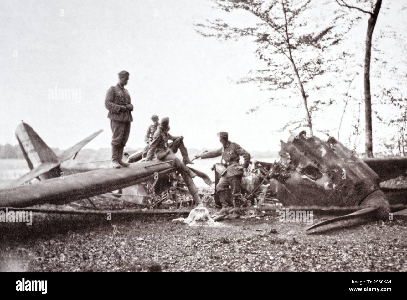 Ein ANF Les Mureaux 113 stürzte ab und brannte aus, als deutsche Soldaten während des Zweiten Weltkriegs inspizierten. Stockfoto