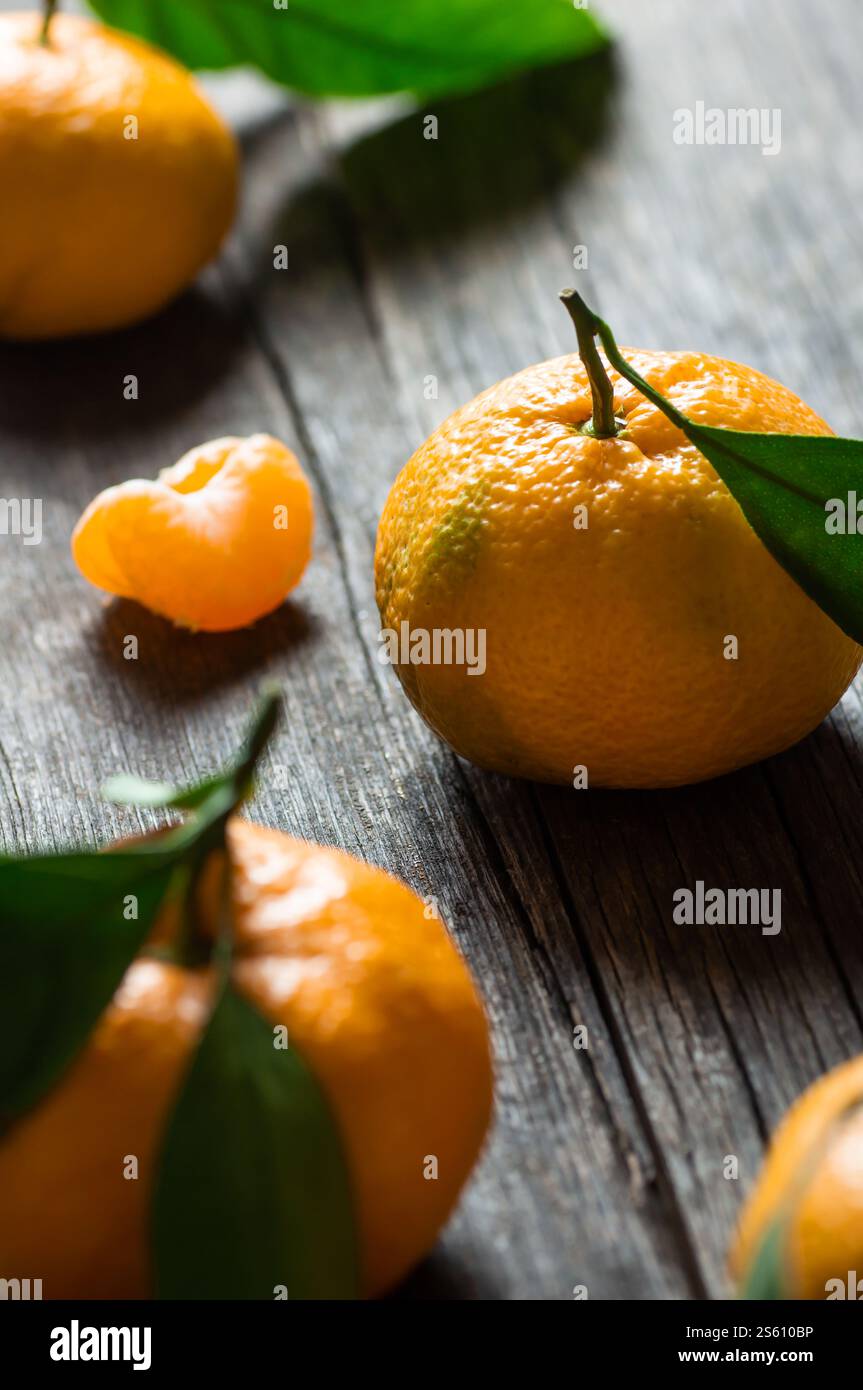Frische reife saftige gelbe Mandarine ( Clementine, Mandarine ) auf rustikalem Vintage-Tisch mit Blatt. Winterfrucht Hintergrundkonzept Stockfoto