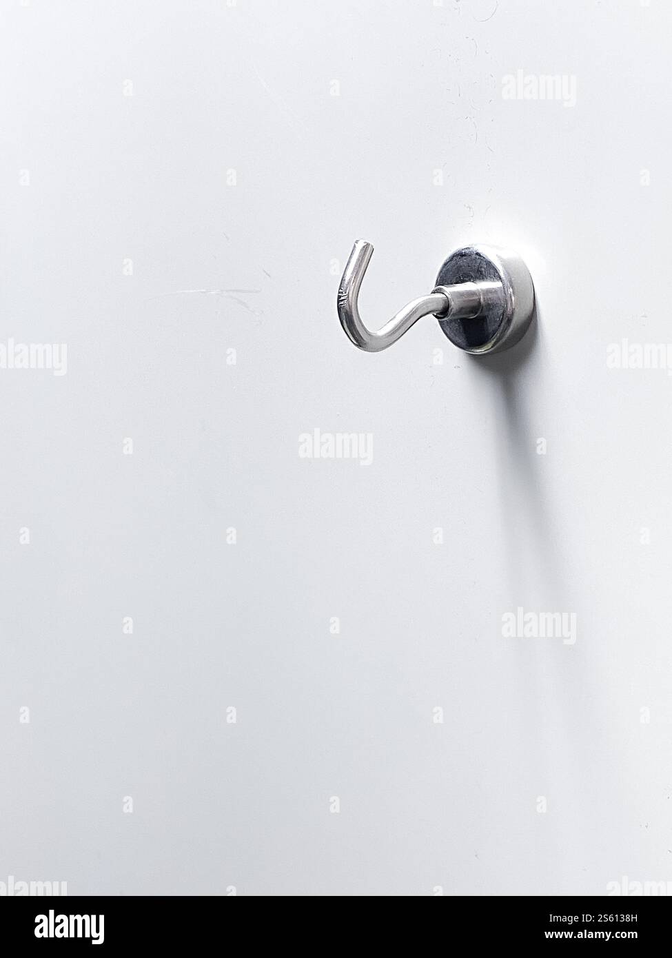 Metallschlüssel an weißer Wand, Vorlage für Objekt, Kleiderbügel an der Wand Stockfoto