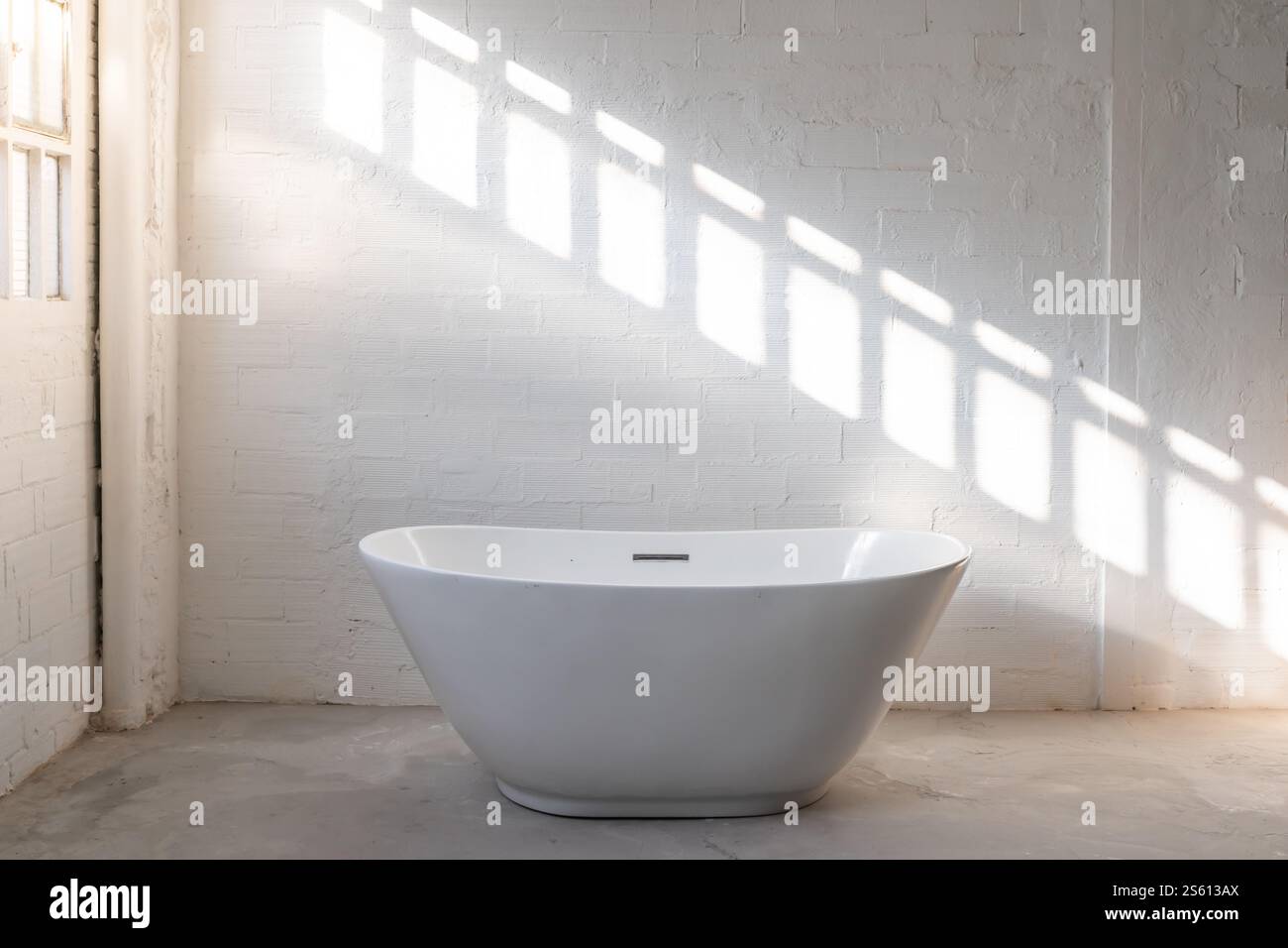 Moderne freistehende Badewanne, die perfekt zu einem minimalistischen Badstil passt Stockfoto
