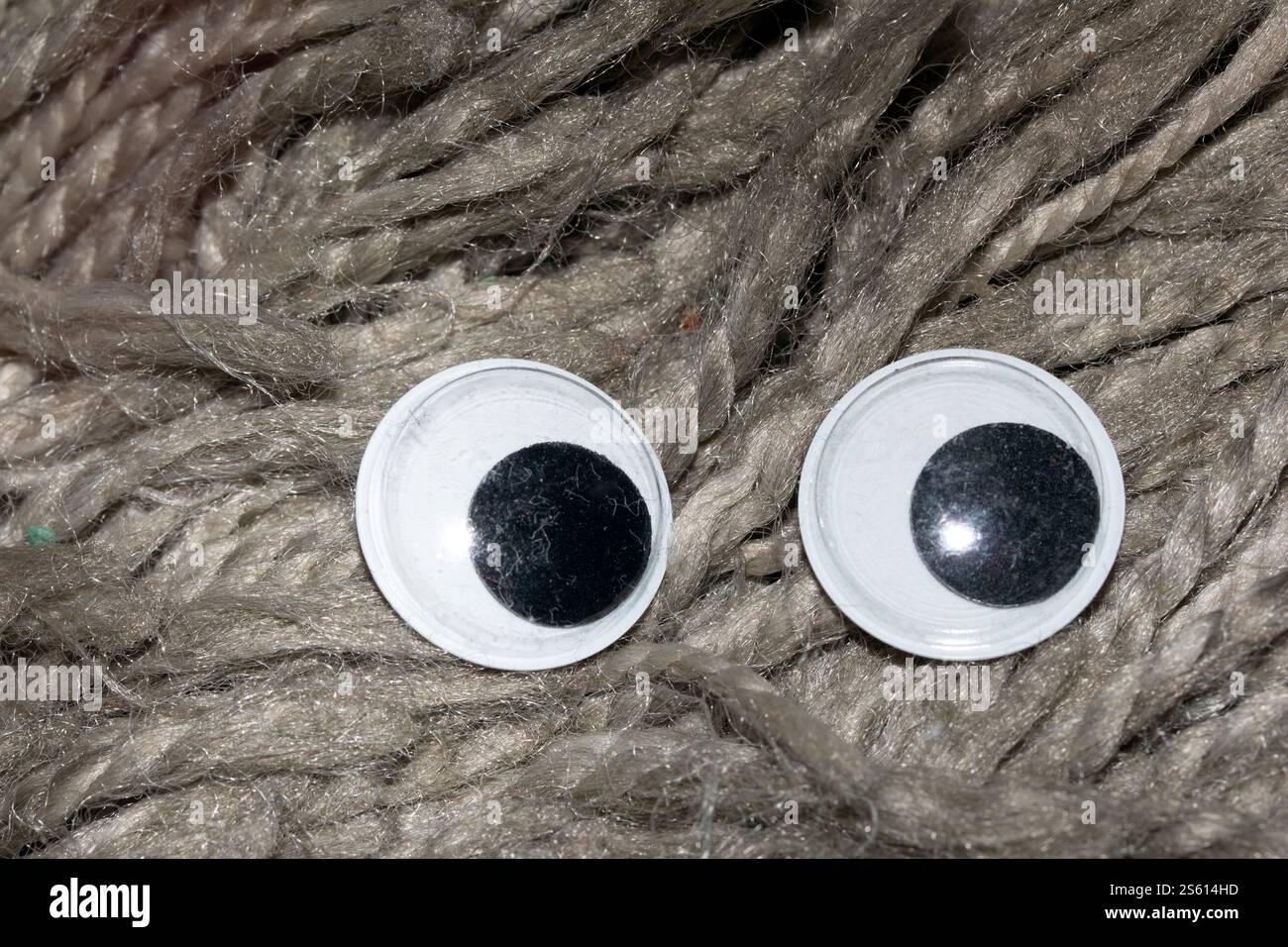 Lustiges Wiggle Google Eyes auf Stoff dumm Pelz Hintergrund Stockfoto