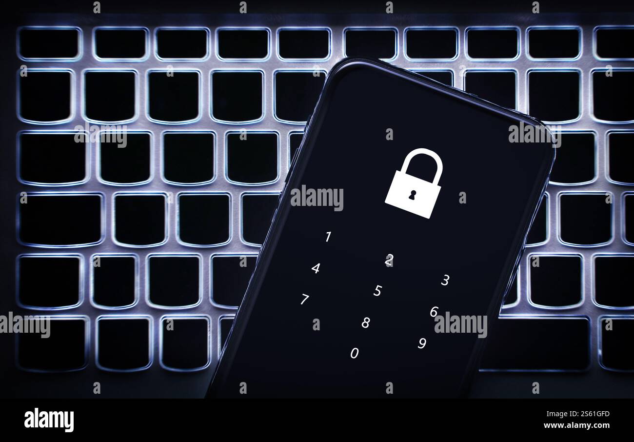 Datenschutz per Telefon mit Kennwortcode. Smartphone auf Laptop-Tastatur. Sperren, um persönliche Banken vor Hacker, Cyberbetrug oder Online-Betrug zu schützen. Stockfoto