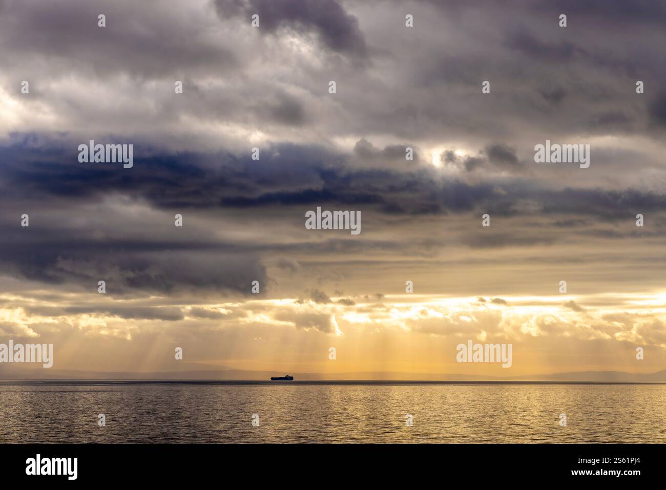 Sonnenstrahlen, die durch die dunklen Wolken auf einem Schiff in der adria ragen, erzeugen einen dramatischen Effekt Stockfoto