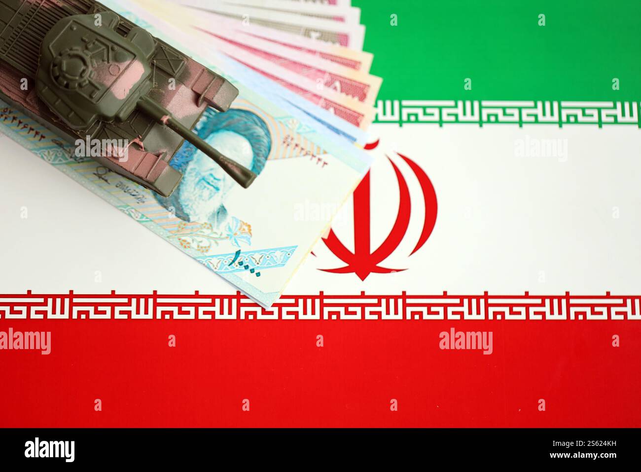 Iranische Armee Spielzeugpanzer-Antrieb auf iranischen Rial-Wechseln auf der Flagge der Islamischen Republik Iran Nahaufnahme. Iranische Armee-Spielzeugpanzer-Antrieb auf iranische Stockfoto