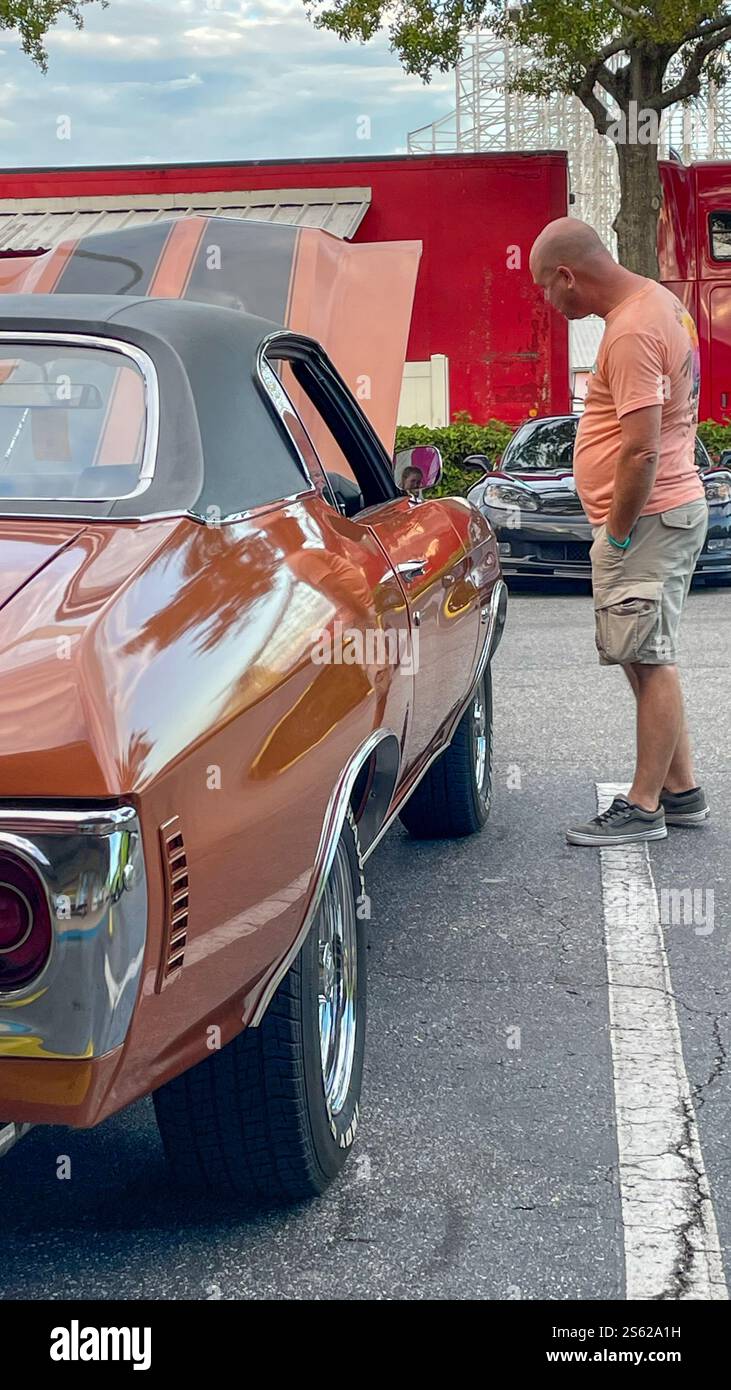 Mann, der Red Chevy Chevrolet Chevelle ansieht - Smartphone-aufgenommenes Stockfoto