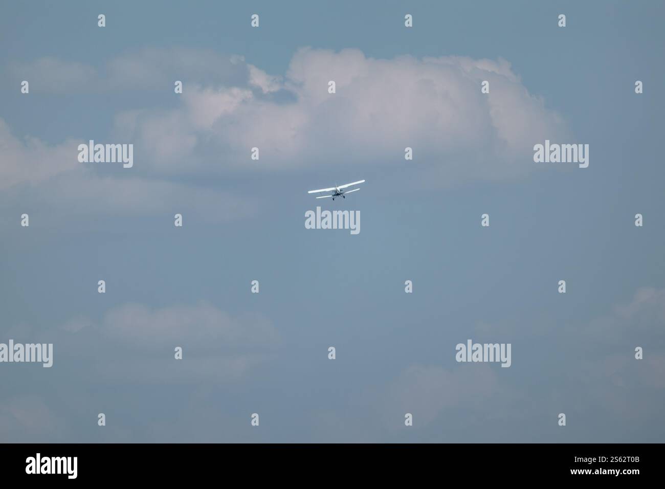 Ein-2-Doppeldecker-Passagierflugzeug, das in blauem Himmel mit malerischen Wolken fliegt Stockfoto