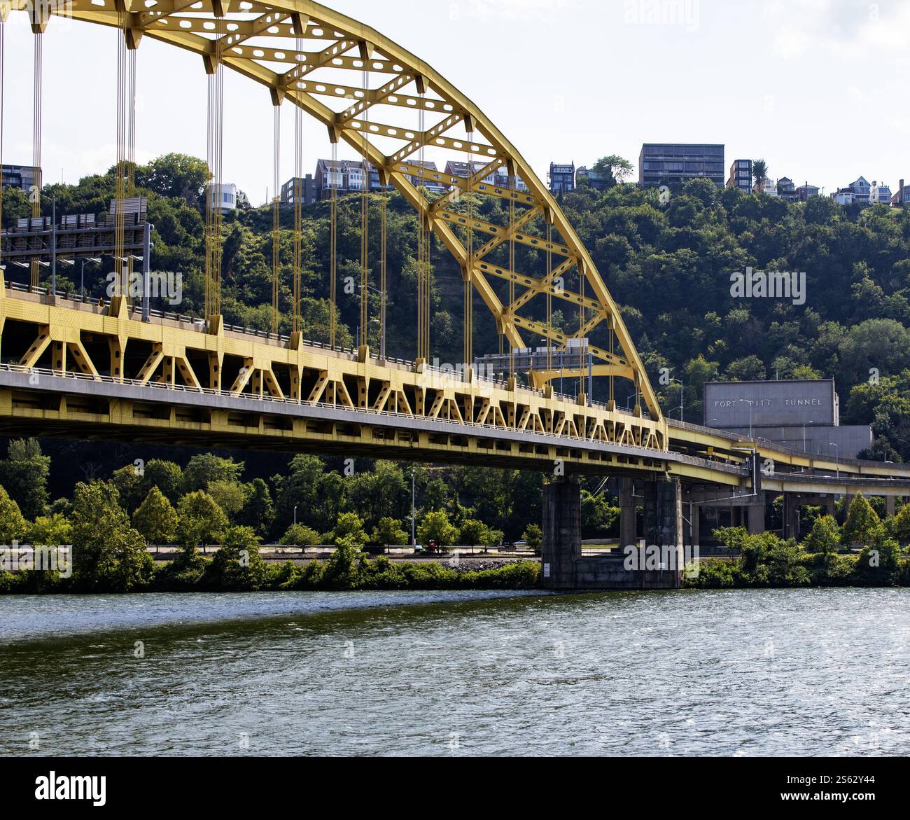 Pittsburgh, Pennsylvania, USA - 8. August 2023: Eine lebhafte gelbe Brücke verbindet den Fort Pitt Tunnel, umgeben von üppigem Grün. Stockfoto