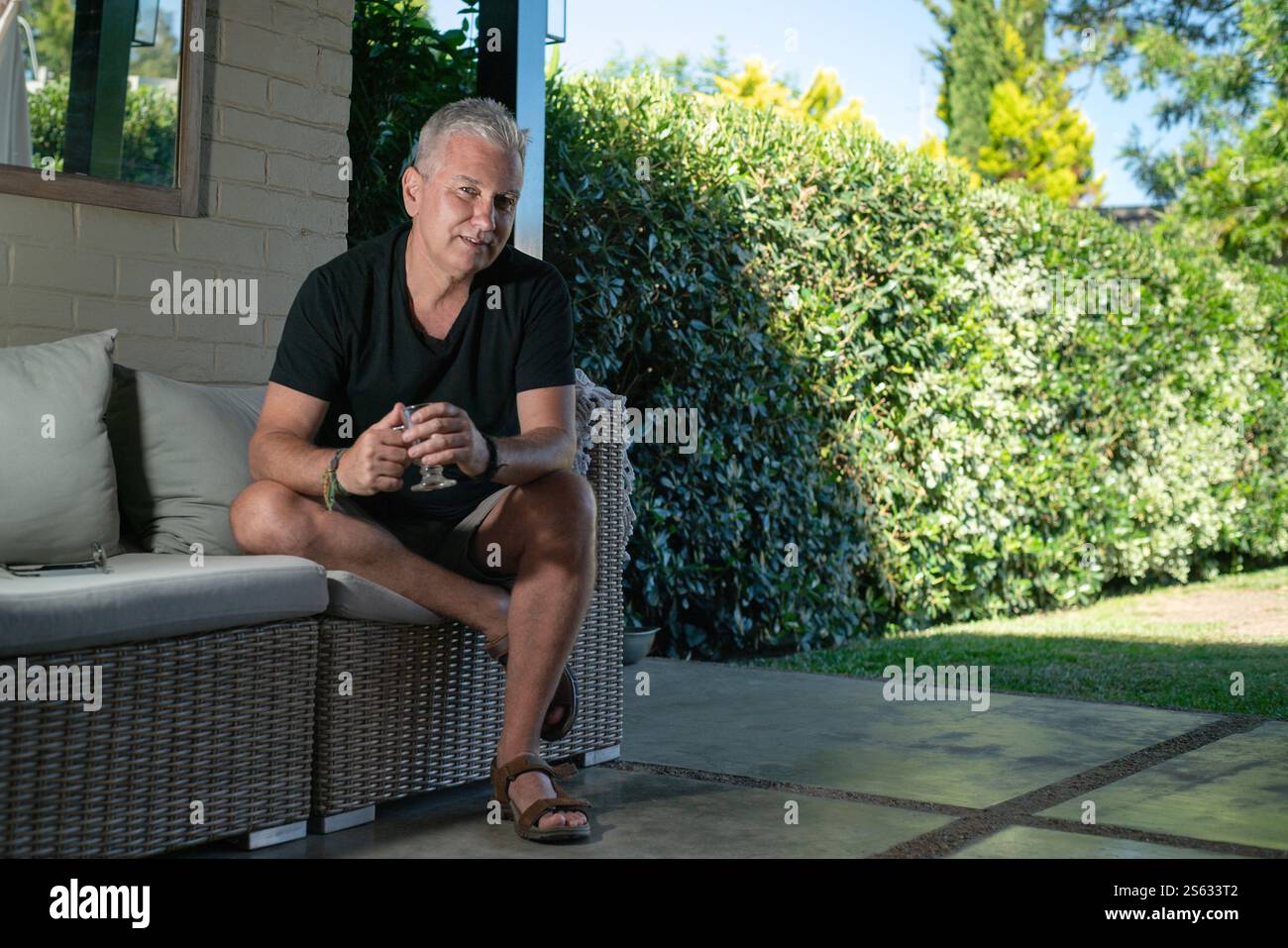 Reifer Mann auf der Terrasse zu Hause in einer komfortablen Kaffeepause. Stockfoto