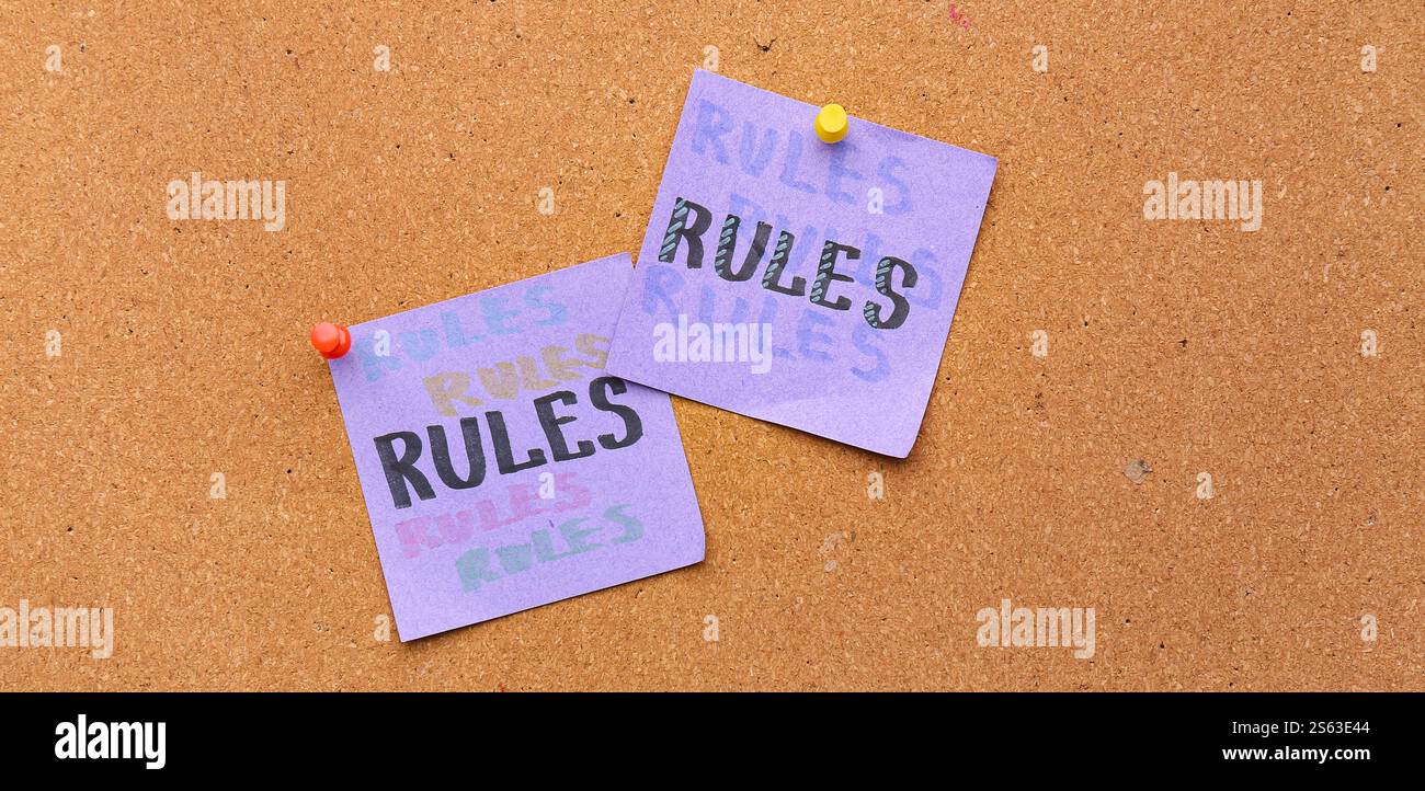 Festgeklemmte Papiere mit WORTREGELN an Bord Stockfoto