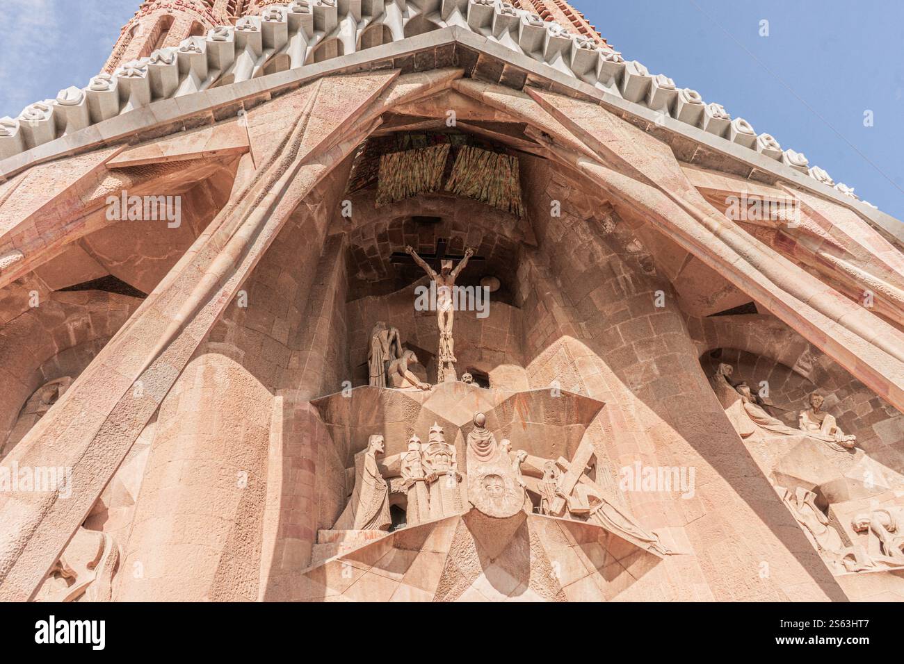 Außenansicht der Sagrada Familia mit einer eindrucksvollen Darstellung von Jesus am Kreuz, die Gaudí einzigartigen architektonischen Stil zeigt. Stockfoto