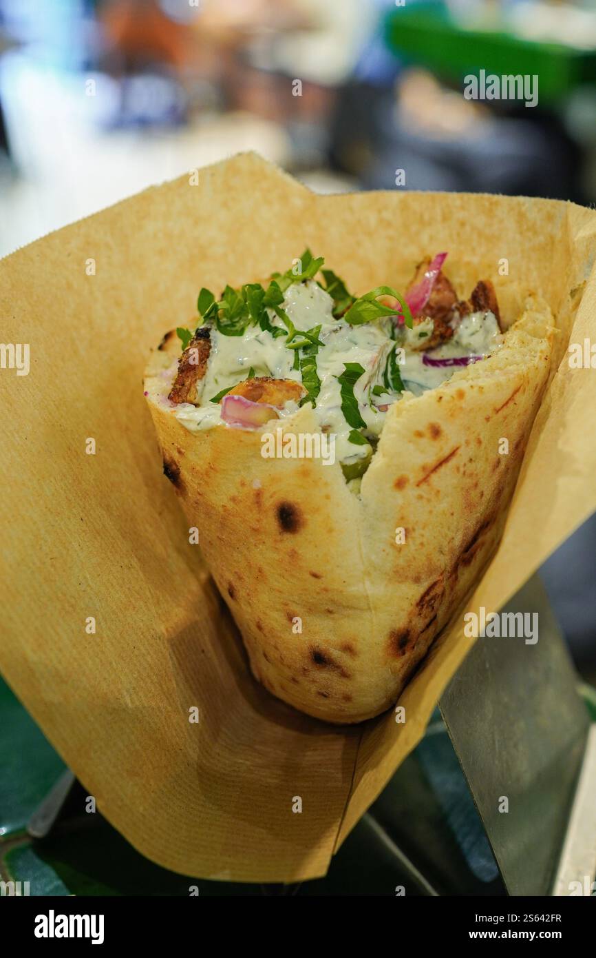 Pita-Sandwich mit gegrilltem Huhn, Kohl und knusprigen Zwiebeln Stockfoto
