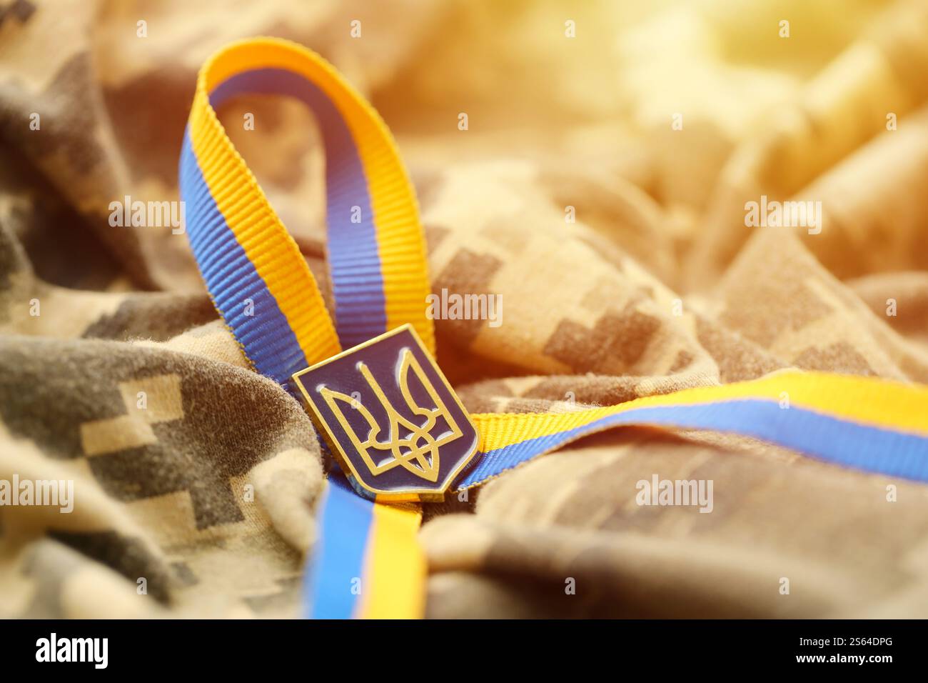 Gepixelter digitaler Militärtarnstoff mit ukrainischer Flagge und Wappen auf Streifenband in blauen und gelben Farben. Attribute von ukrainisch Stockfoto