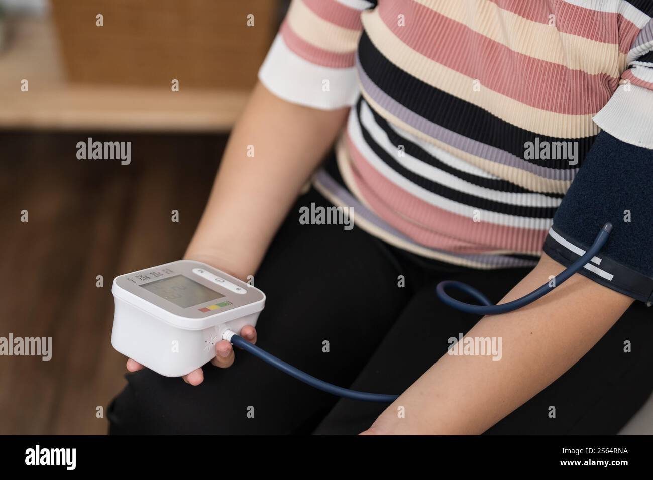 Übergewichtige Frauen plus Größe Selbstkontrollen Blutdruck und Herzfrequenztonometer Selbstkontrolle zu Hause. Stockfoto