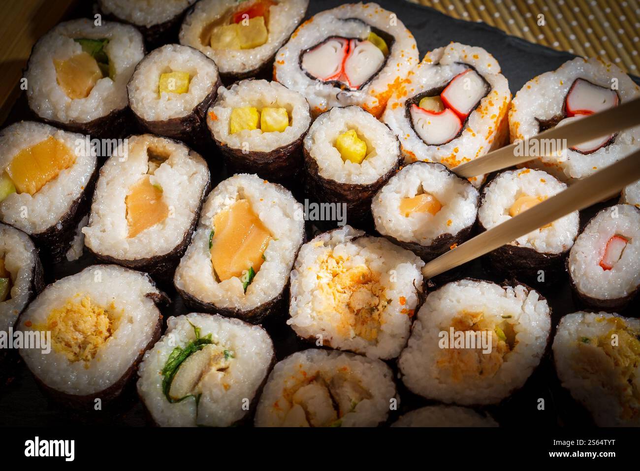 Verschiedene Sushi-Brötchen werden auf dem Schiefertablett serviert Stockfoto