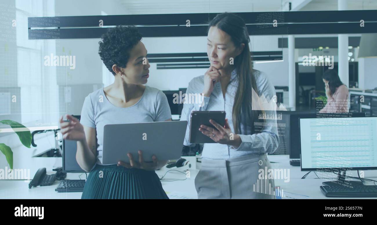 Bild der Analyse von Geschäftsdaten über zwei Frauen, die über die Arbeit im Büro sprechen Stockfoto