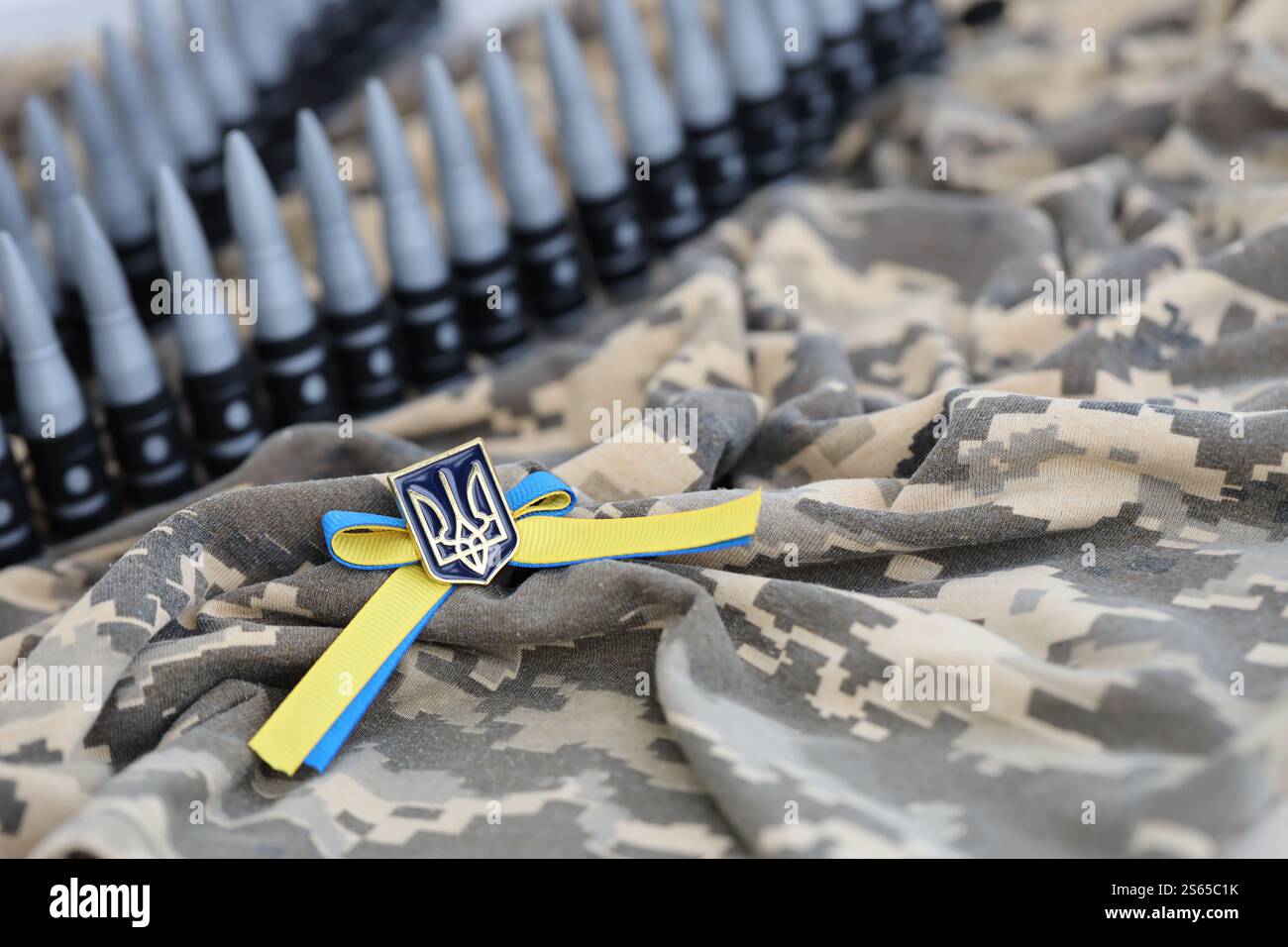 Ukrainisches Symbol und Maschinengewehrgürtel auf der Tarnuniform eines ukrainischen Soldaten. Der Begriff Krieg in der Ukraine, Patriotismus und Schutz Stockfoto
