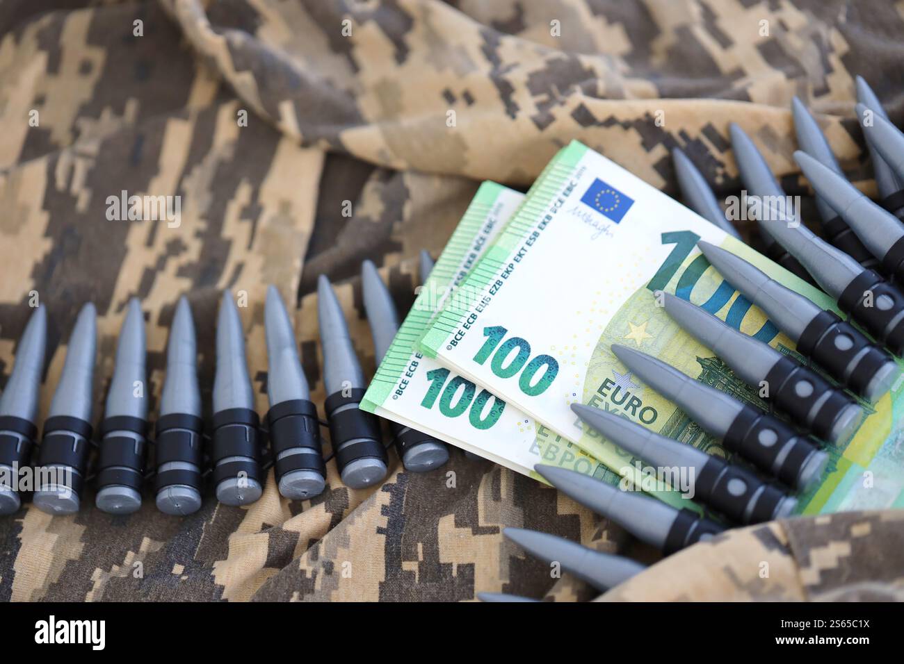 Bündel Euroscheine und ein Maschinengewehrgürtel auf der Tarnuniform eines ukrainischen Soldaten. Konzept der Kriegsfinanzierung, Bestechung oder Spende. Hilfe zu Stockfoto