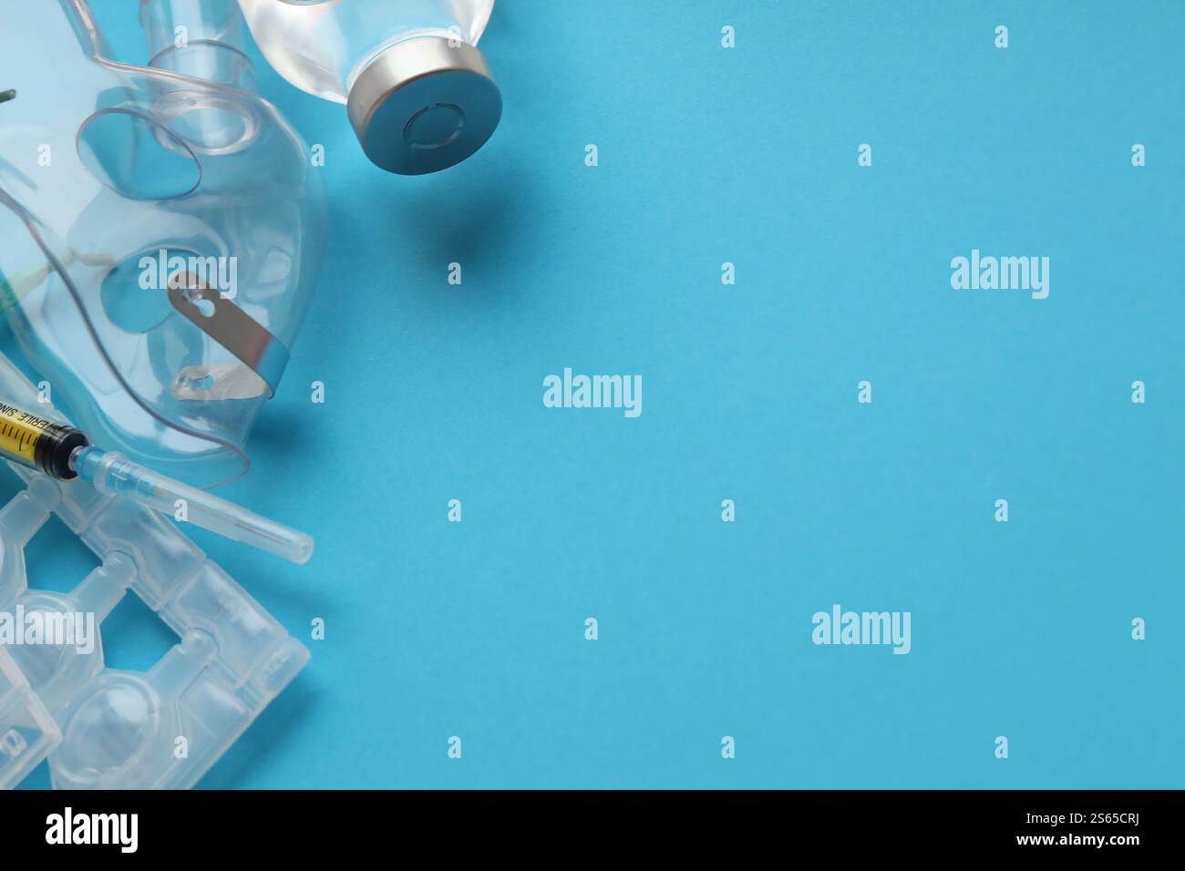 Coronavirus-Behandlungskonzept. Ein medizinischer Gesichtsmasken-Vernebler für die Behandlung der Atemwege und Ampullen flach auf blauem Hintergrund gelegt. Stockfoto