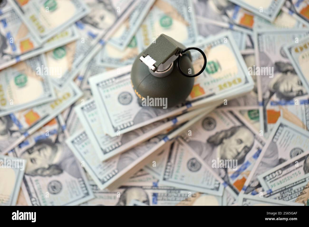 Granate mit einem Scheck vor dem Hintergrund einer riesigen Menge amerikanischer Dollarscheine aus der Nähe. Granate mit einem Scheck vor dem Hintergrund von Riesen Stockfoto