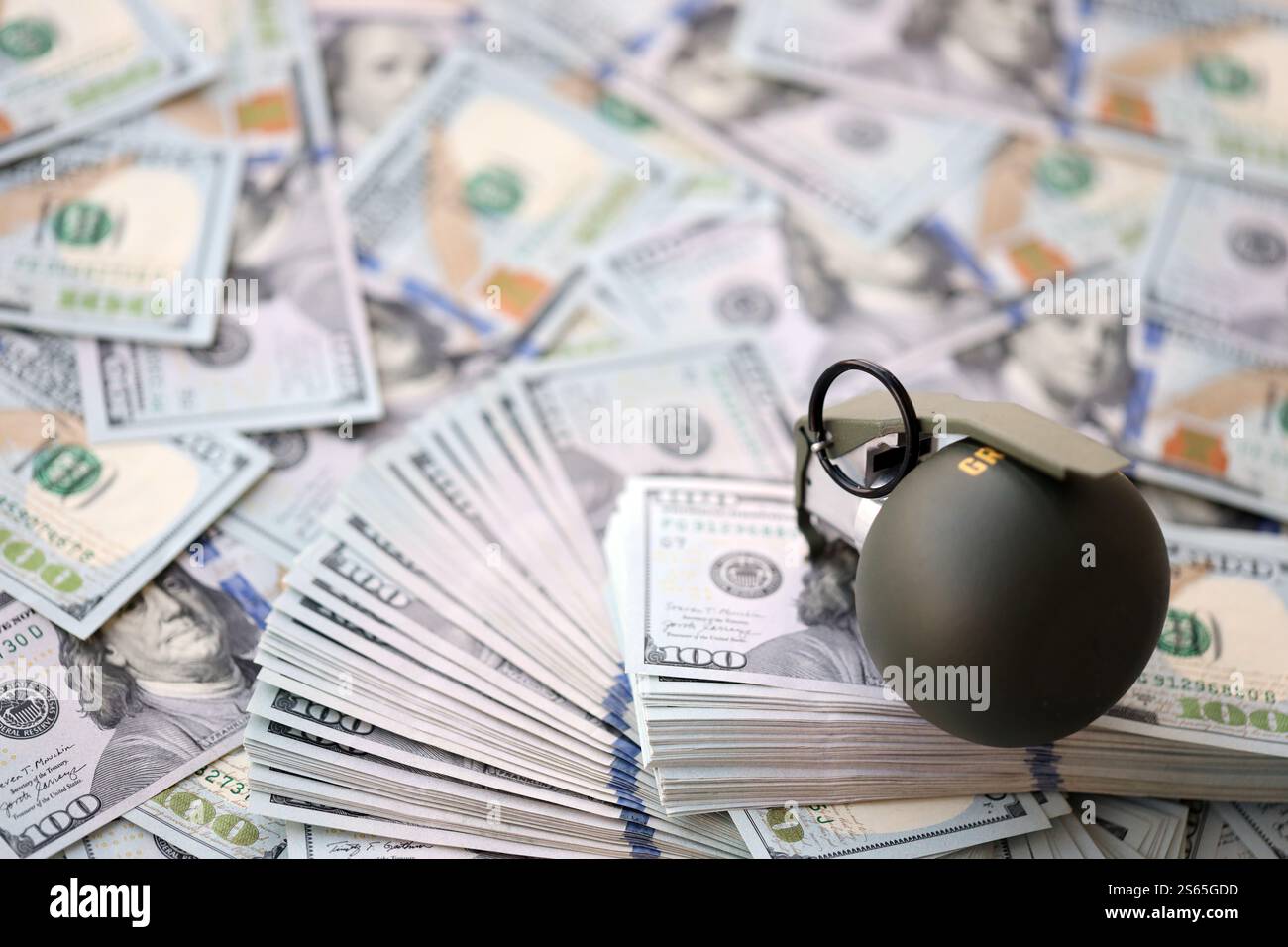 Granate mit einem Scheck vor dem Hintergrund einer riesigen Menge amerikanischer Dollarscheine aus der Nähe. Granate mit einem Scheck vor dem Hintergrund von Riesen Stockfoto