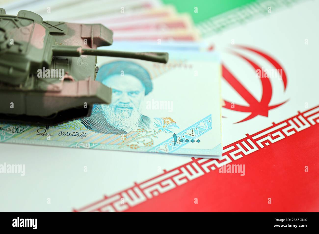 Iranische Armee Spielzeugpanzer-Antrieb auf iranischen Rial-Wechseln auf der Flagge der Islamischen Republik Iran Nahaufnahme. Iranische Armee-Spielzeugpanzer-Antrieb auf iranische Stockfoto