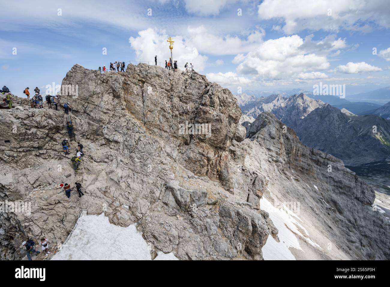 Touristen stellen sich an den Gipfel der Zugspitze, Gipfel mit goldenem Gipfelkreuz, Übertourismus, Wettersteinkette, Bayern, Deutschland, Europa Stockfoto