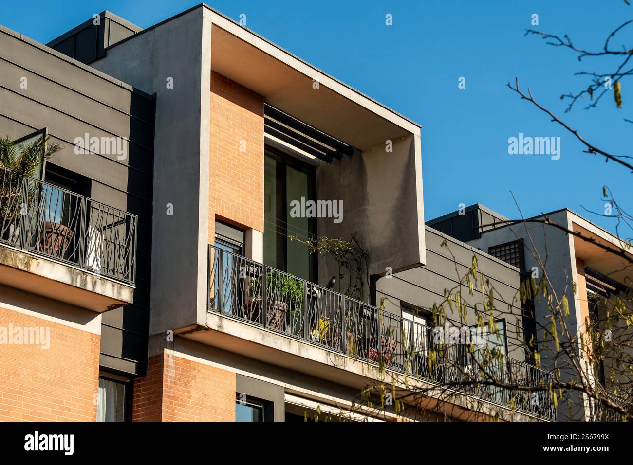 Moderne Architektur mit eleganten Balkonen unter klarem blauen Himmel Stockfoto