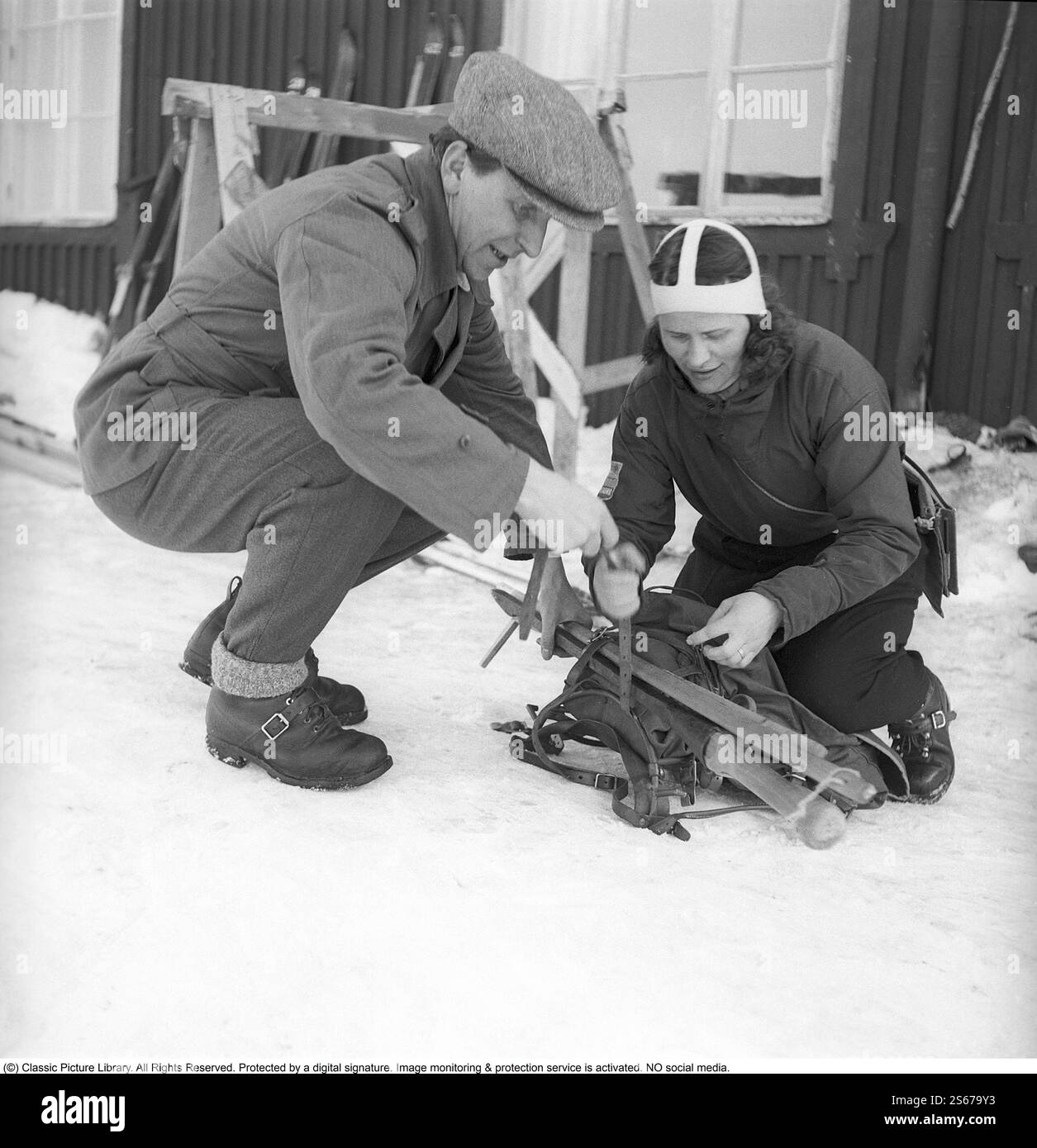 Sie, die das Wetter in den Bergen verfolgt. Es ist die Wetterbeobachterin Anna-Lisa Wikdahl in Riksgränsen in Nordschweden, die sechsmal am Tag ihre Messungen macht und die Instrumente liest. Anschließend ruft sie die Ergebnisse an den Wetterdienst in Stockholm. Hier wird sie beobachtet, wie sie sich auf den Skiern in die Wildnis zur Maßposition vorbereitet und ihre Sachen packt. 1943 Kristoffersson Ref. D108-4 Stockfoto