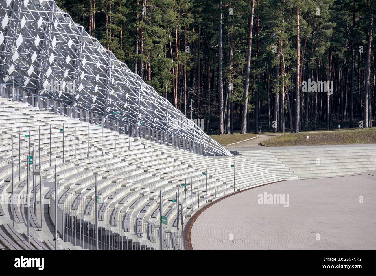 Ein leeres Amphitheater mit Betonsitzen in einem bewaldeten Bereich mit einem ungewöhnlichen geometrischen Baldachin. Stockfoto