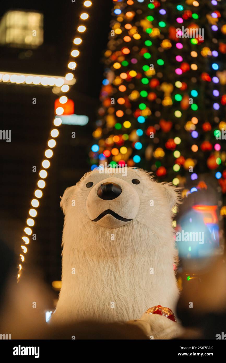 Kopf eines Eisbären vor dem Hintergrund eines Weihnachtsbaums. Durchgehendes Spielzeug auf einer Party Stockfoto