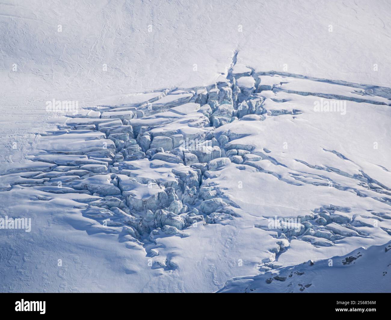 Ein Blick aus der Vogelperspektive auf komplizierte Schneeformationen in den französischen Alpen. Der Wind hat den Schnee zu einem faszinierenden Muster geformt. Stockfoto