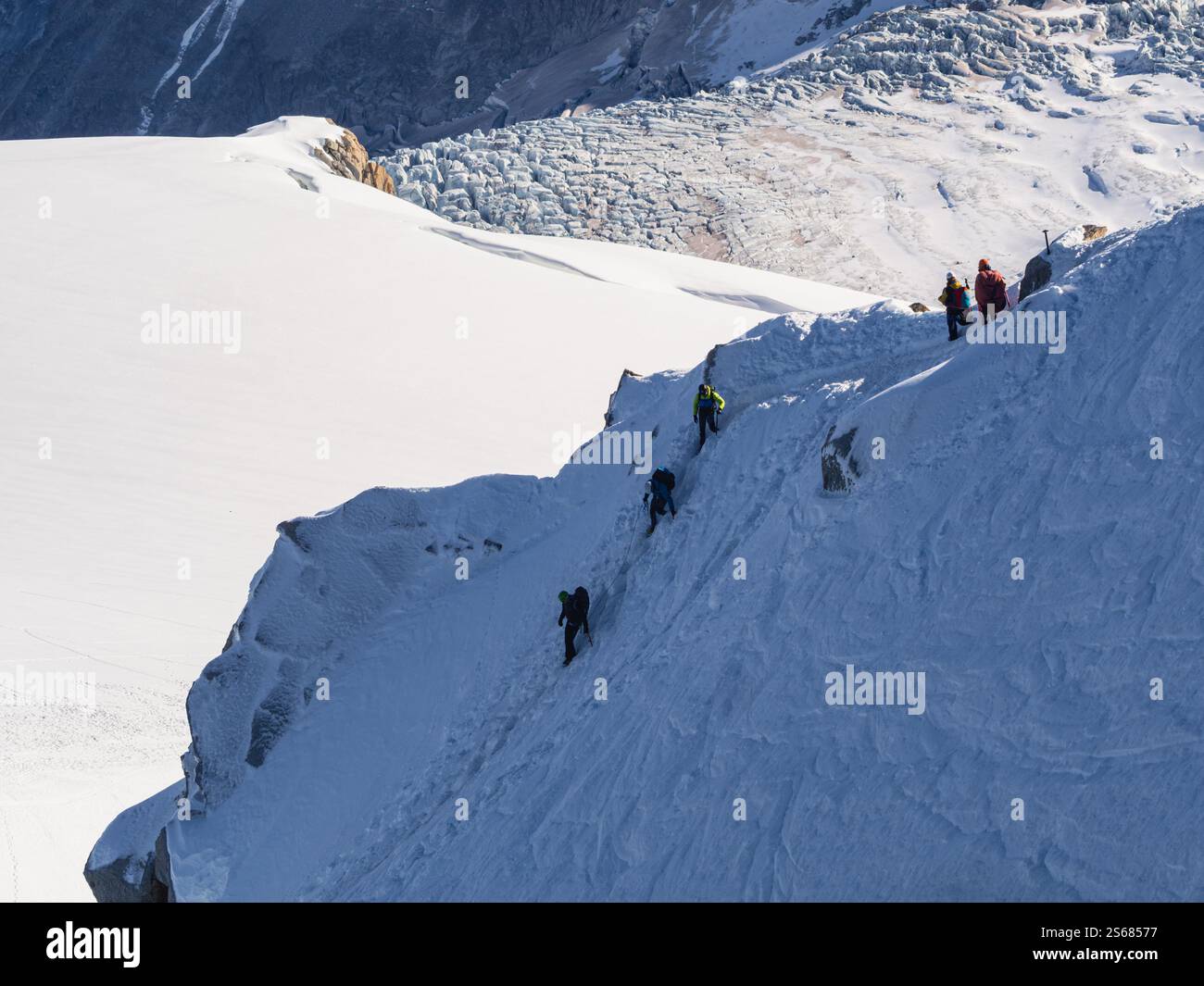 Bergsteiger erklimmen die steilen, verschneiten Hänge von Aiguille du Midi – Eine reine alpine Herausforderung im Herzen von Chamonix Stockfoto