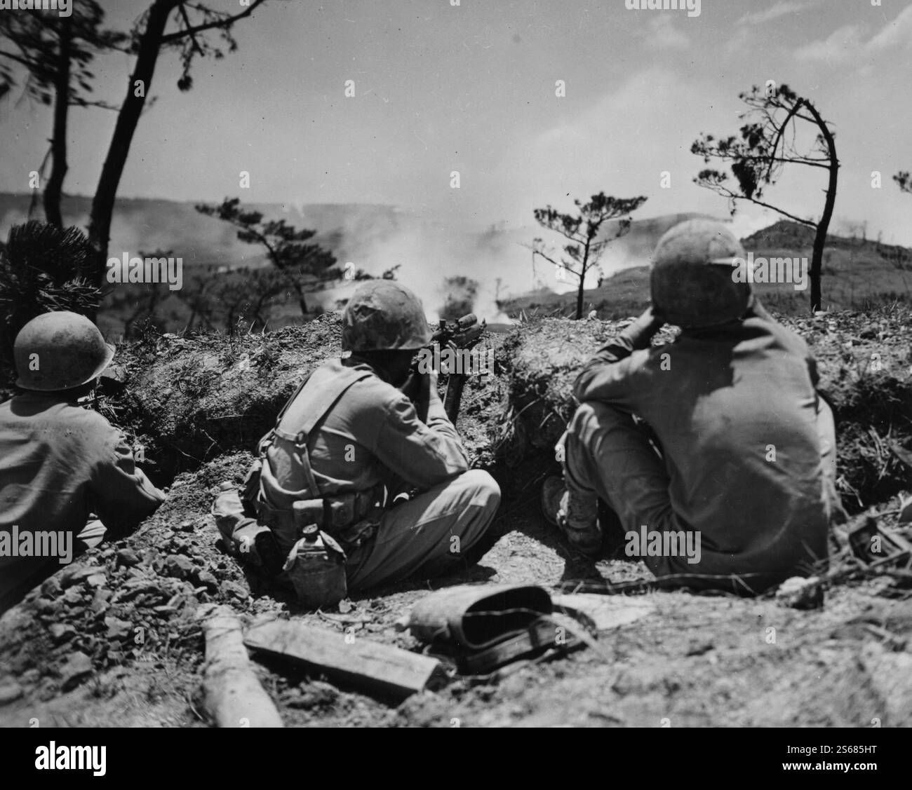 OKINAWA, JAPAN - 1945 - Ein US-Marine-Scharfschütze zielt auf japanische Ziele auf einem Hügel während der Schlacht von Okinawa, die eine der blutigsten und blutigsten war Stockfoto