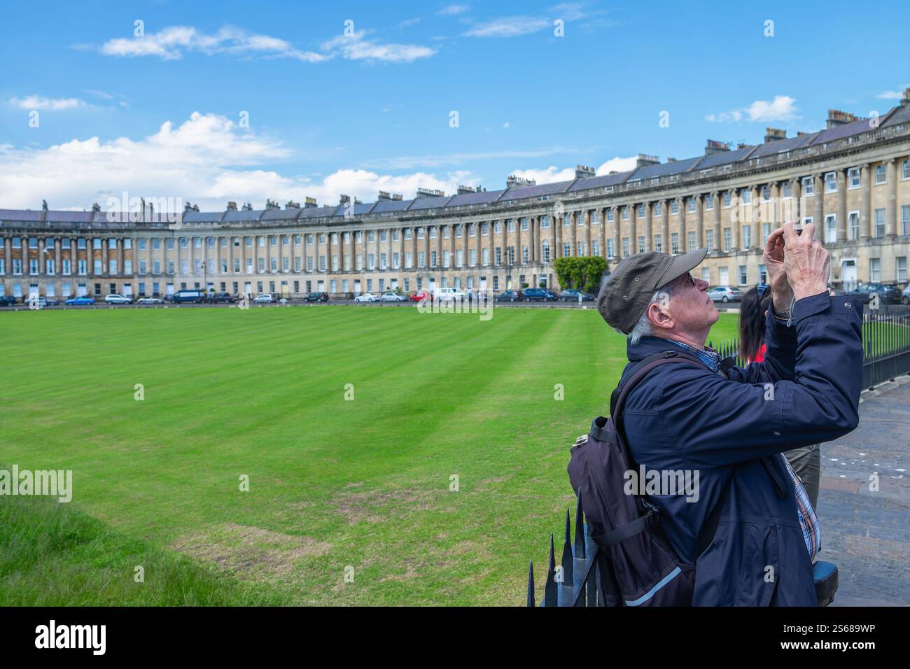 Ein Tourist wird fotografiert, während er ein Foto des berühmten Royal Crescent in Bath, England Somerset, Großbritannien macht Stockfoto