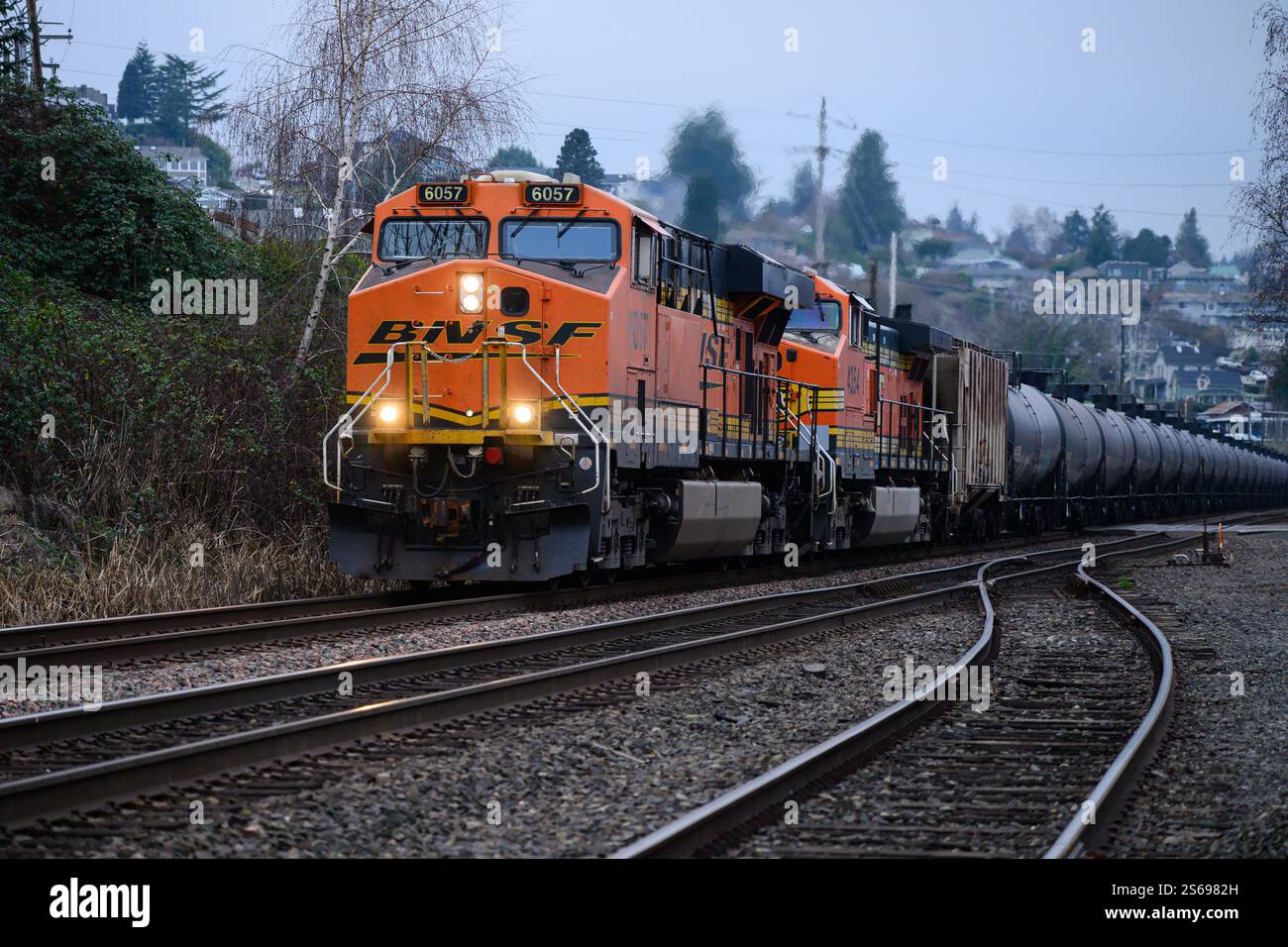 Tacoma, WA, USA - 14. Januar 2025; abendliche BNSF-Ölbahn, die durch Tacoma fährt und die Lichter eingeschaltet sind Stockfoto