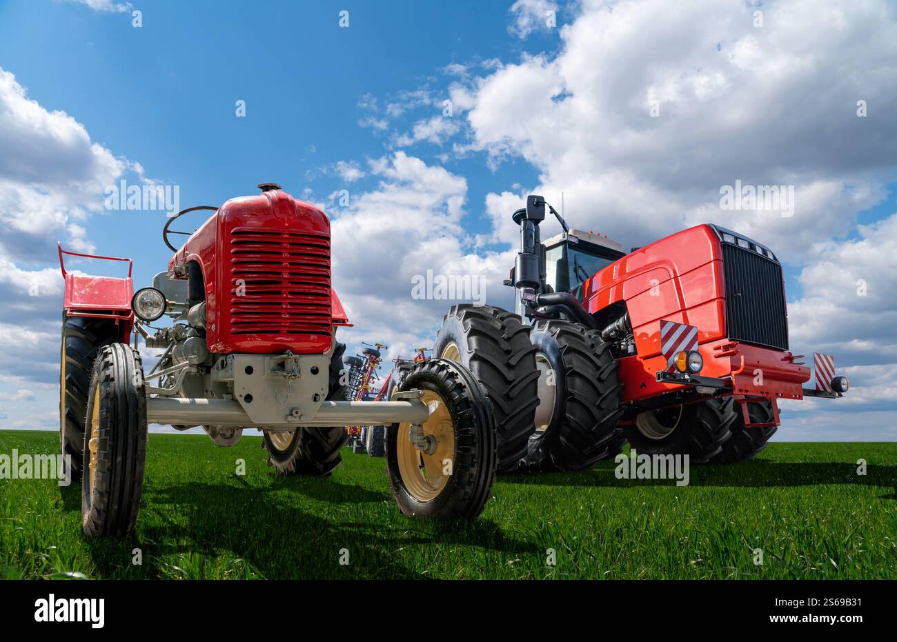 Alter Traktor und neuer moderner Traktor. Entwicklung landwirtschaftlicher Maschinen. Stockfoto