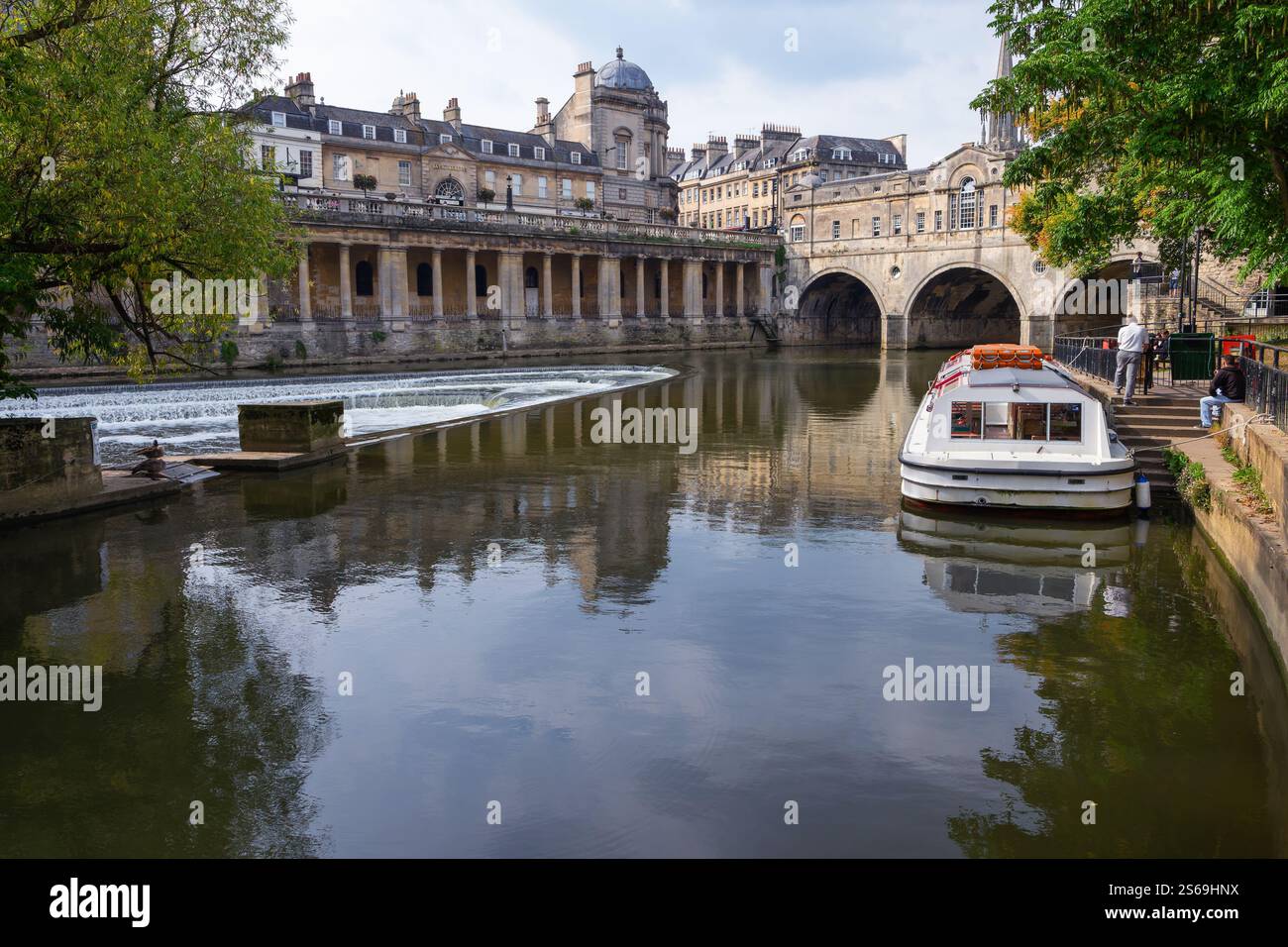 Touristenboote, die in der Nähe der berühmten Pulteney Brücke und des Pulteney Weir am Fluss Avon in Bath, England, liegen. Stockfoto
