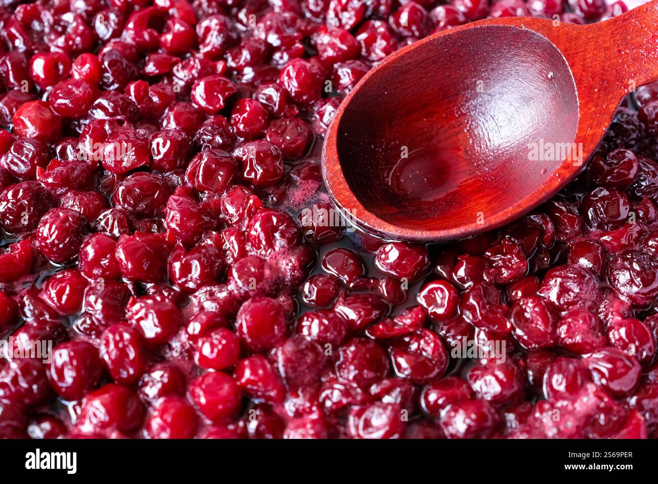 Hausgemachte Kirschmarmelade. Holzlöffel. Rezept. Stockfoto