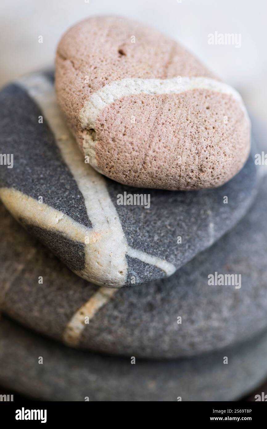 Gestapelte Strandkiesel mit weißen Adern, Makronaht. Stockfoto