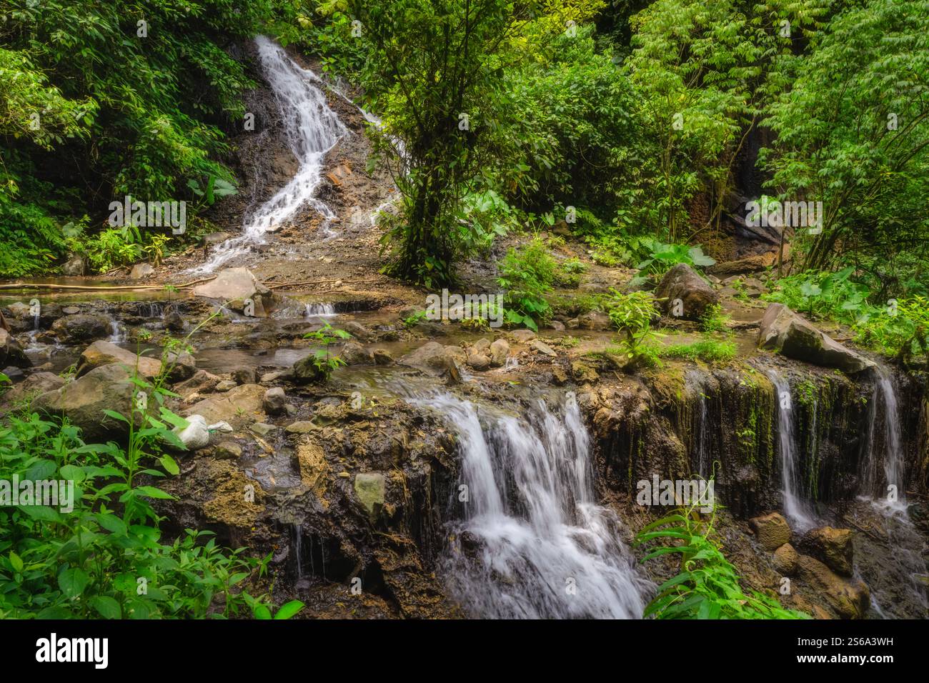 Ein atemberaubender Tumpak Sewu Wasserfall stürzt felsige Klippen hinunter, umgeben von üppigem Grün, und schafft eine idyllische Umgebung für Entspannung und Inspiration Stockfoto