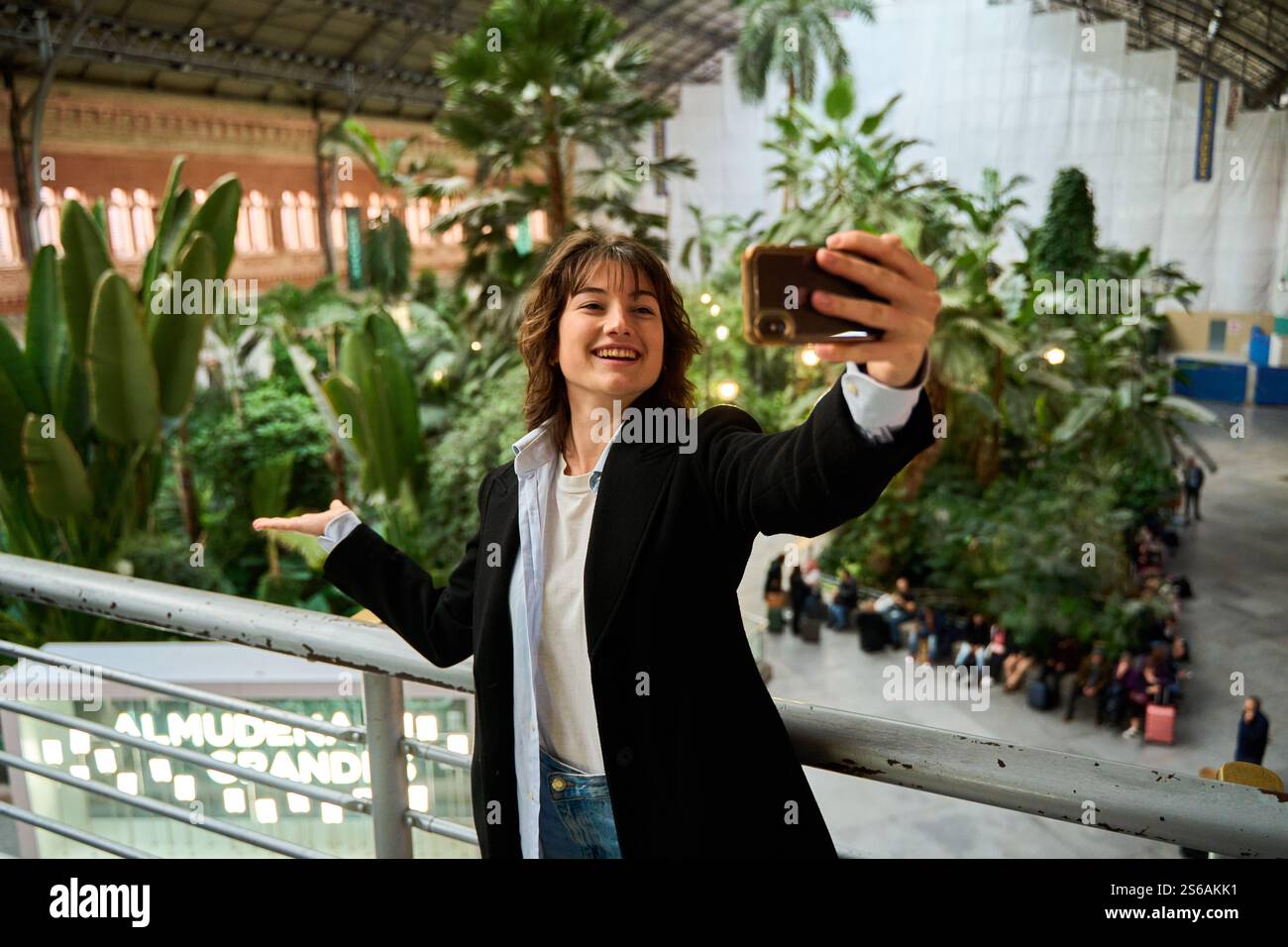 Touristen machen Selfie am Bahnhof atocha in madrid und zeigen den tropischen Garten im Gebäude Stockfoto