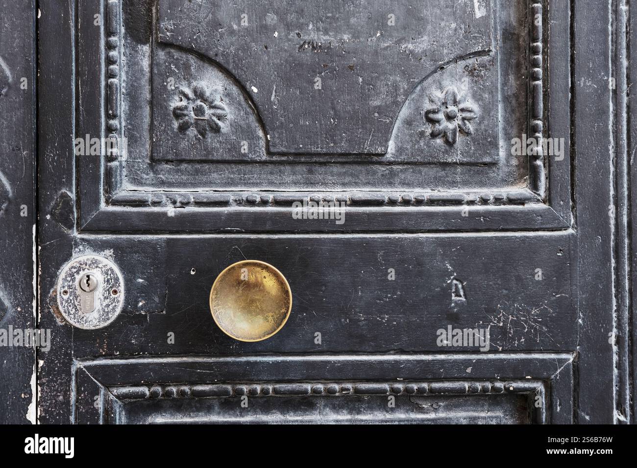 Alte schwarze Holztür mit goldfarbenem Türknauf Stockfoto