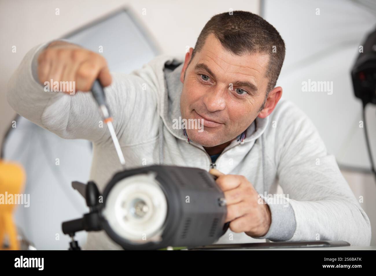 Fotograf Löten wireless flash Trigger an seinem Arbeitsplatz Stockfoto