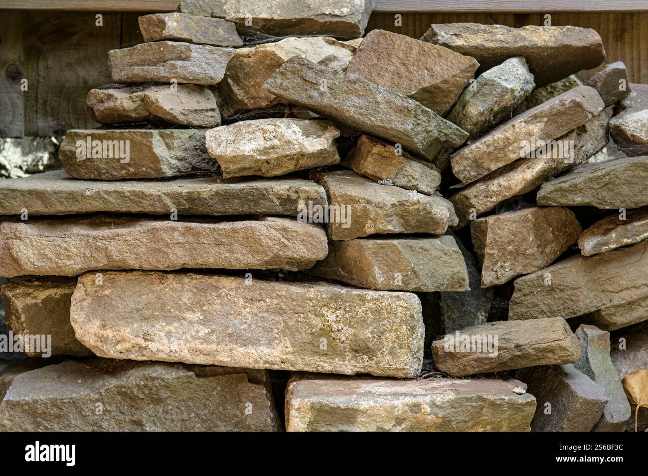 Alte Steinmauerziegel stapelten sich im Garten in Bristol Stockfoto