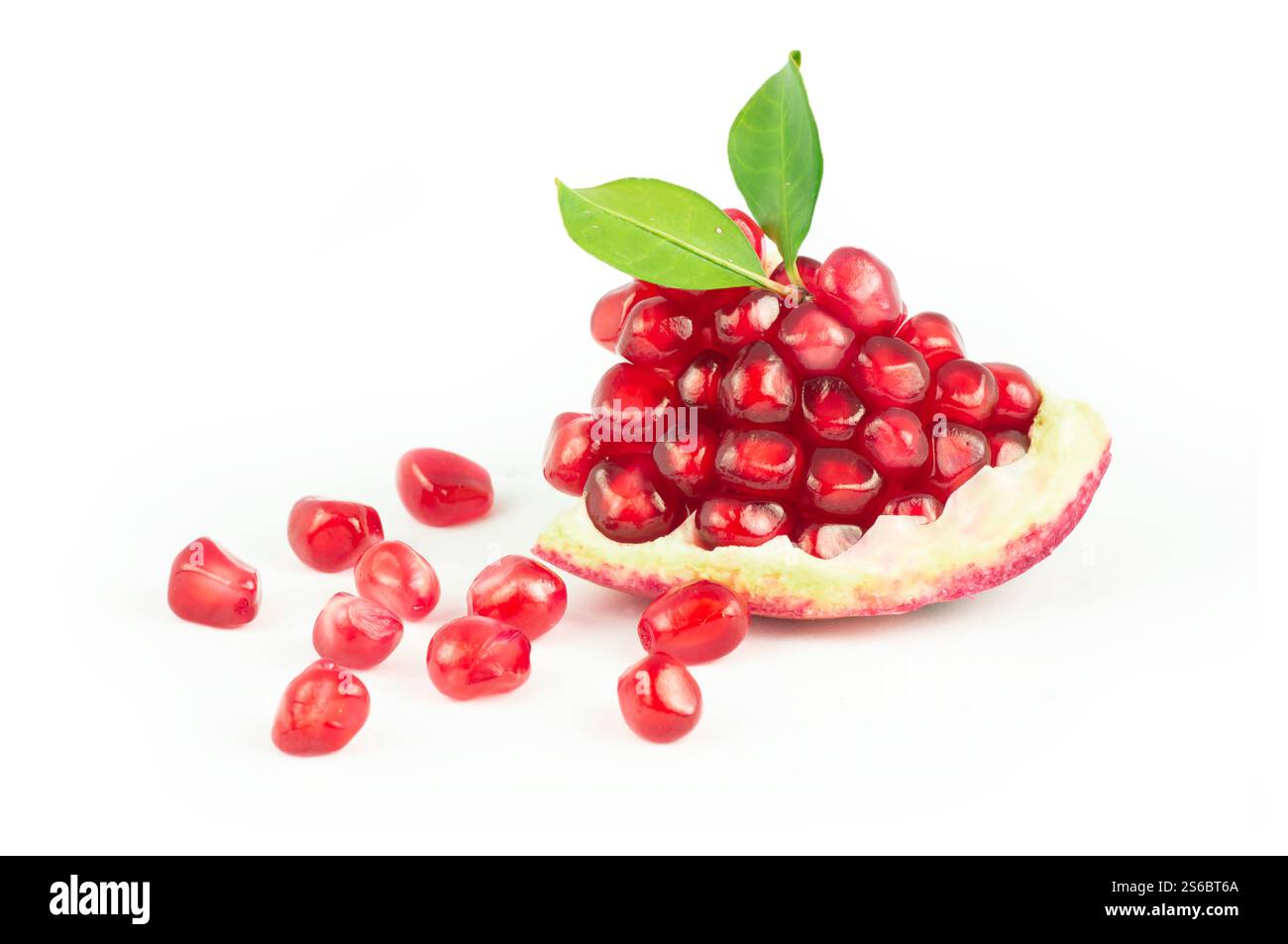 Frischer reifer ganzer und gespaltener saftiger Granatapfel mit Samen und Blättern isoliert auf weißem Hintergrund, gesunde rote Früchte Konzept (Punica granatum) Stockfoto