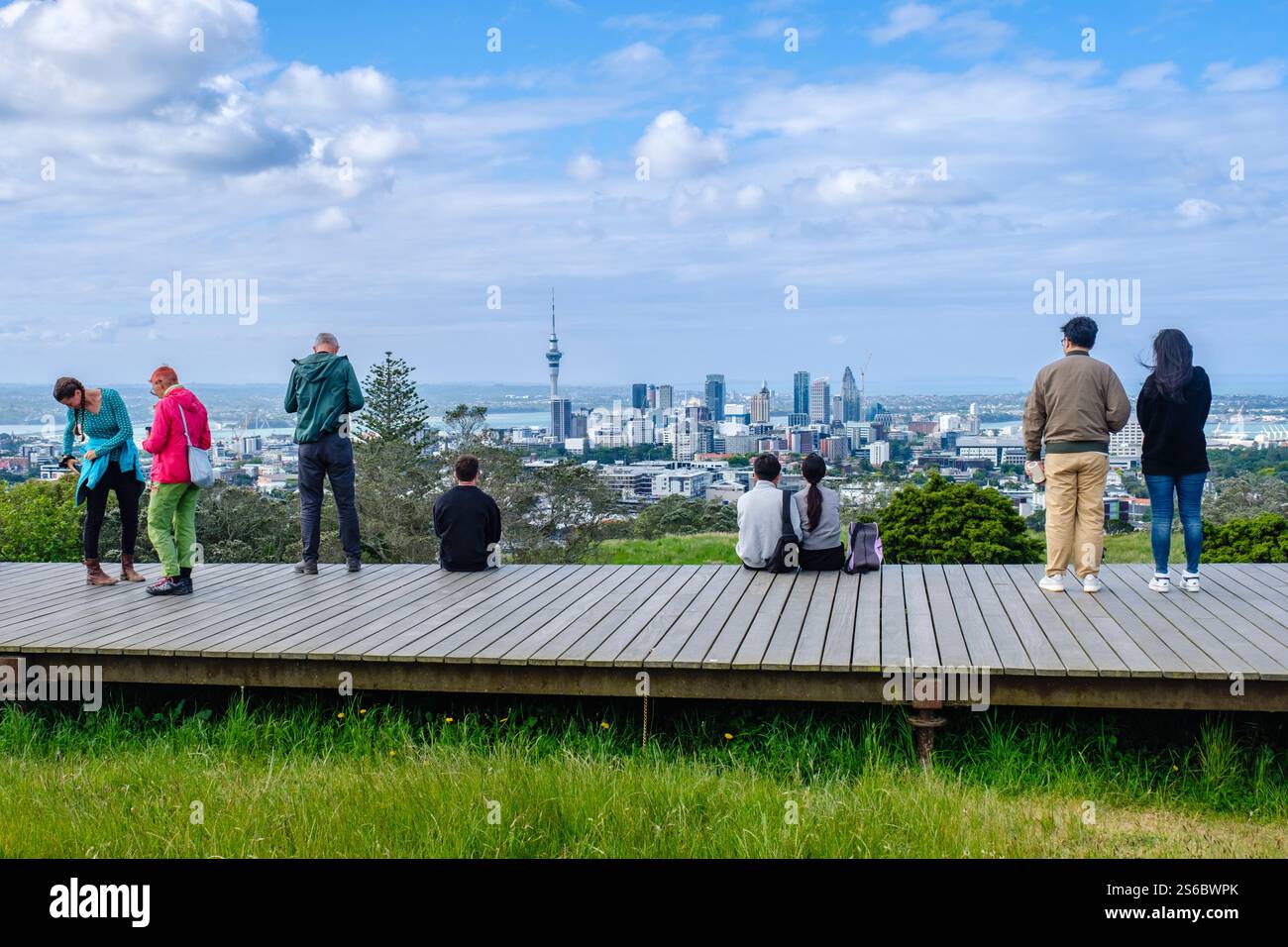 Touristen, Neuseeländer, die die Skyline von Auckland von der Promenade am Mount Eden, dem Skytower, den Gebäuden des zentralen Geschäftsviertels in der Innenstadt, Neuseeland, sehen Stockfoto