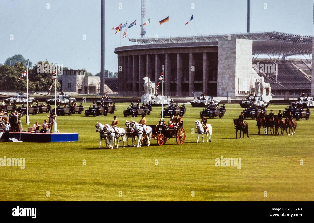 Berlin, Deutschland. 24. Mai 1985. Die britische Monarche Königin Elisabeth II., Prinz Philipp und Prinz Edward saßen während ihres Staatsbesuchs in Berlin am 24. Mai 1985 in einer offenen königlichen Kutsche. Die Kutsche wird von Pferden gezogen und das Olympiastadion ist im Hintergrund sichtbar. Das Bild fängt einen Moment des Auftretens der königlichen Familie vor der Menge während dieses wichtigen Staatsbesuchs in Deutschland ein. Der Besuch erfolgte zu einer Zeit, als Deutschland noch während des Kalten Krieges ein geteiltes Land war. Stockfoto