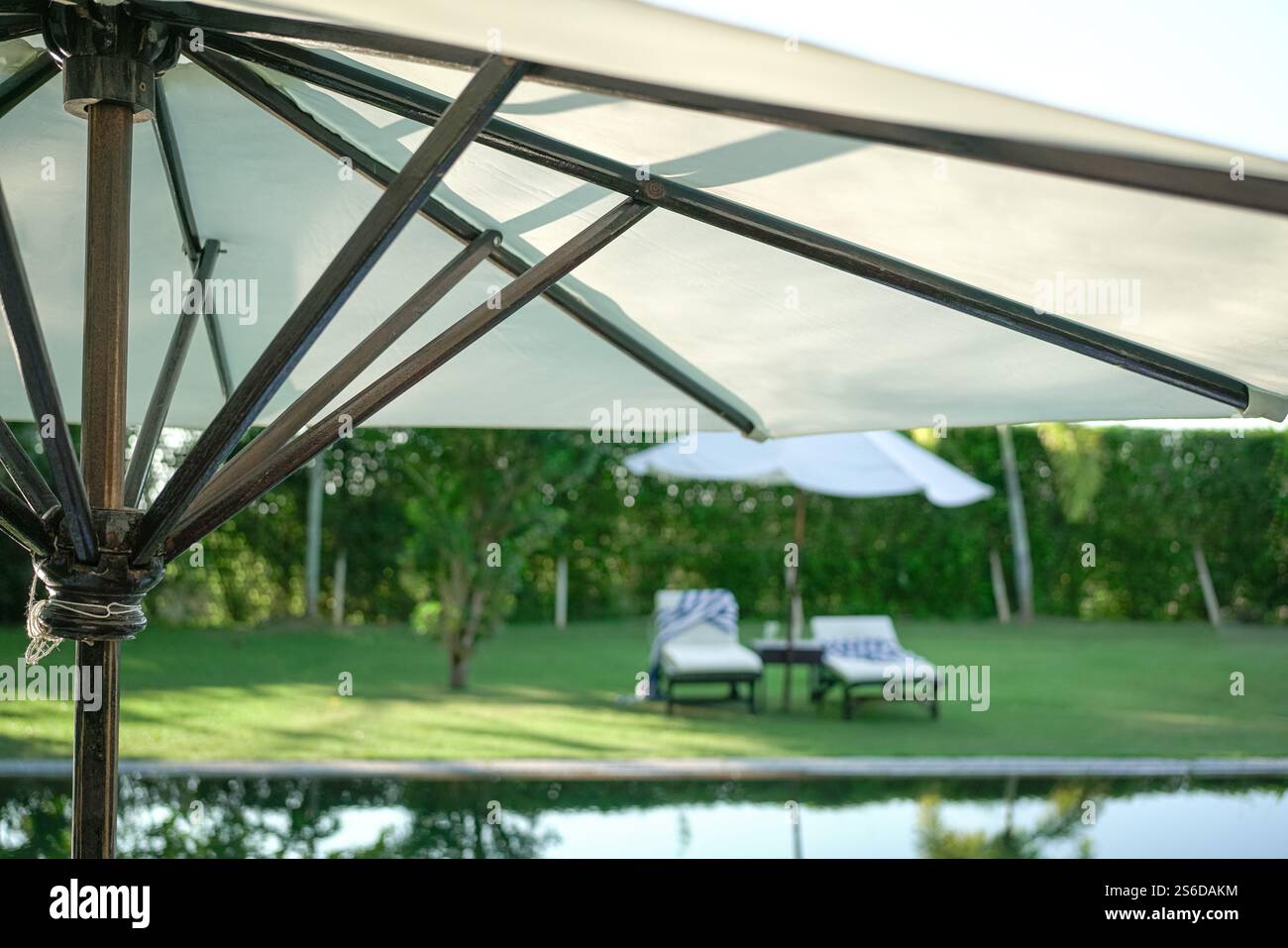 Weißer Pool-Sonnenschirm in einem Wohnhaus mit klimaanlage. Stockfoto